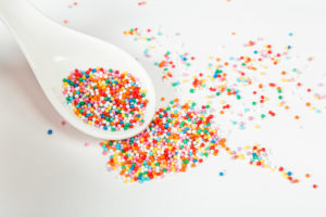 Many points of colored sugar for sprinkling confectionery on ceramic spoon